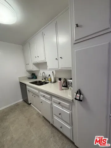 a kitchen with white cabinets and white appliances