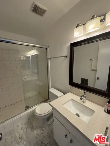 a bathroom with a sink toilet a mirror and shower