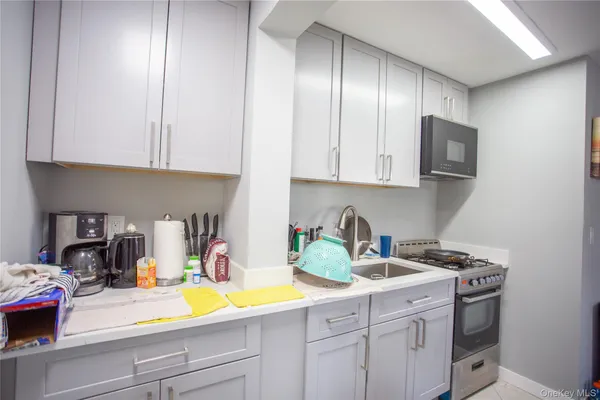 a kitchen with granite countertop white cabinets and sink