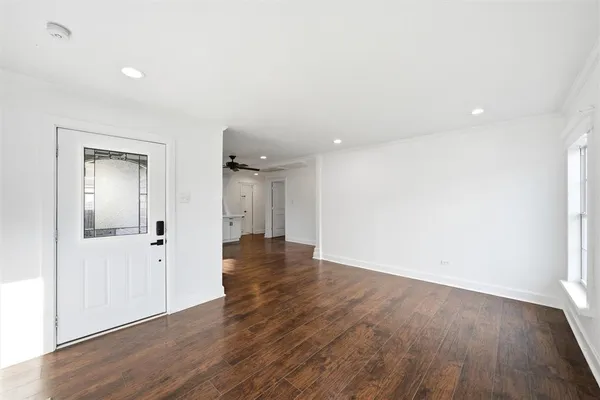 an empty room with wooden floor & windows