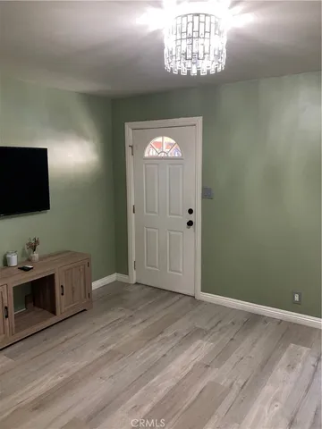 a living room with a dresser and a flat screen tv