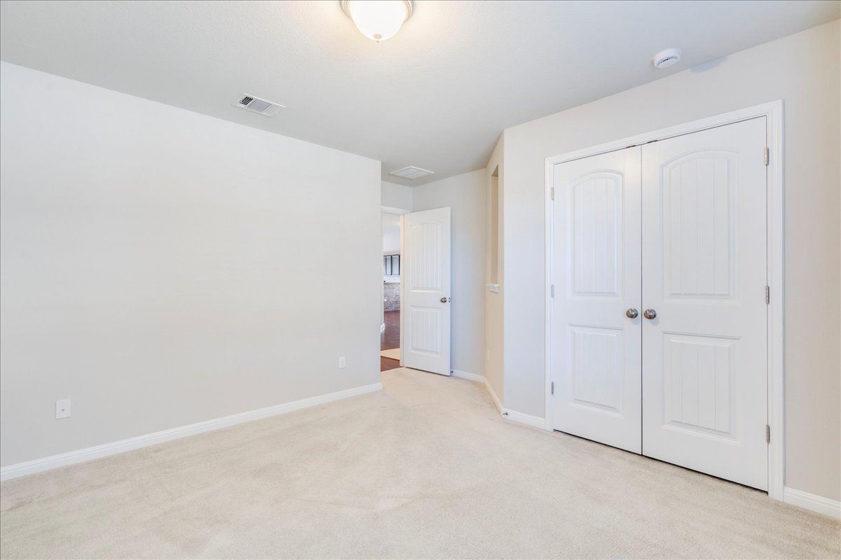 161 Mistflower Lane Kyle, TX 78640 - Photo 24 of 37 Unfurnished bedroom featuring light colored carpet and a closet