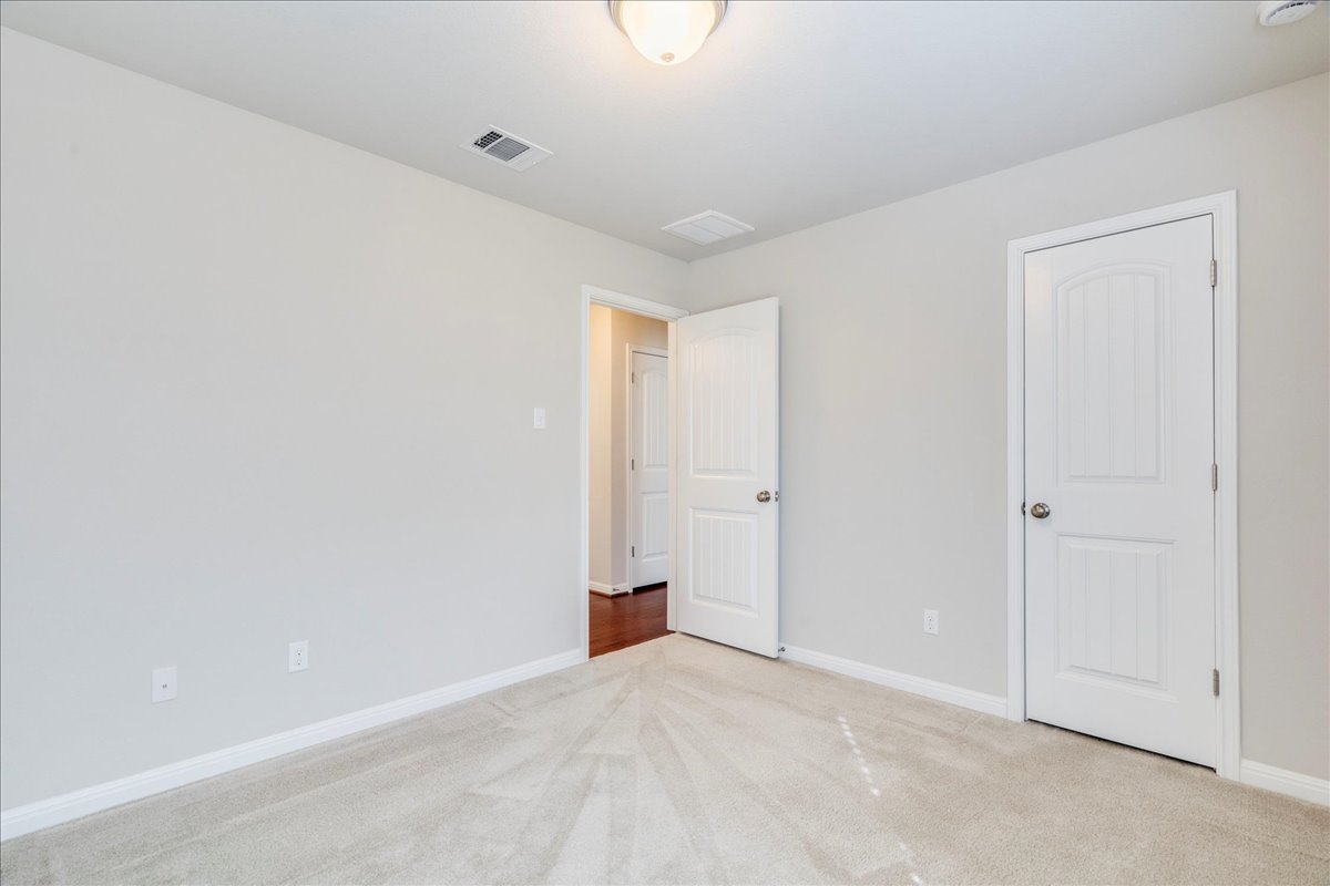 161 Mistflower Lane Kyle, TX 78640 - Photo 30 of 37 Unfurnished bedroom featuring carpet and baseboards