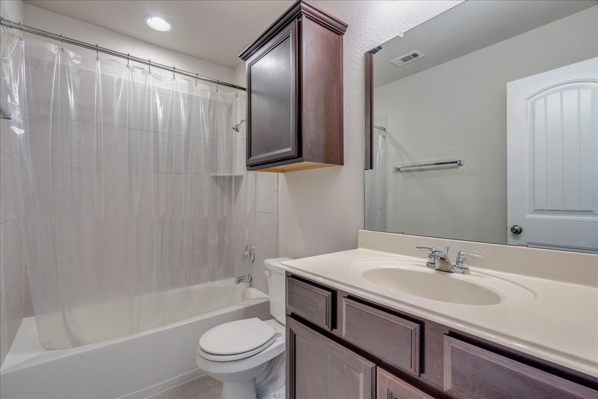 161 Mistflower Lane Kyle, TX 78640 - Photo 31 of 37 Bathroom with vanity, shower / bathtub combination with curtain, recessed lighting, and light tile patterned flooring