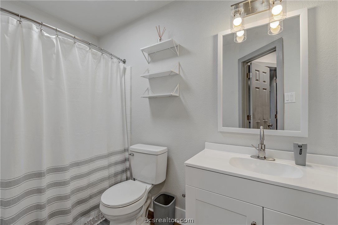1027 Fallbrook Loop College Station, TX 77845 - Photo 14 of 20 a bathroom with a toilet a sink a vanity and mirror