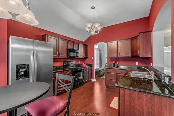 a kitchen with stainless steel appliances granite countertop a stove refrigerator and microwave