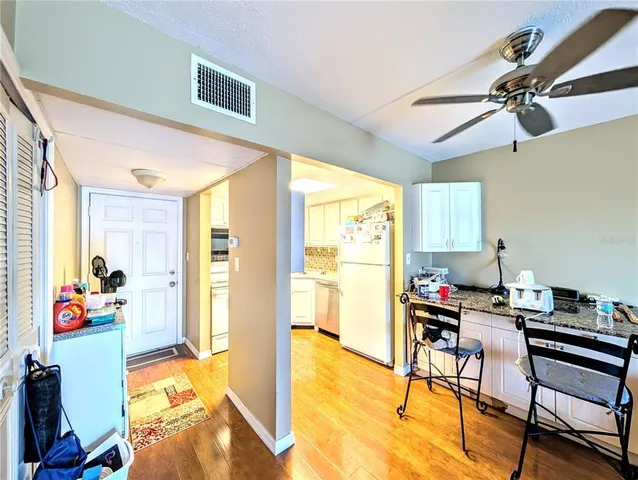 a view of a kitchen with a sink and dishwasher a refrigerator with wooden floor