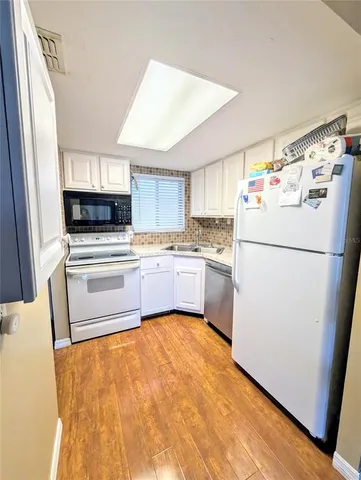 a kitchen with white cabinets and white appliances