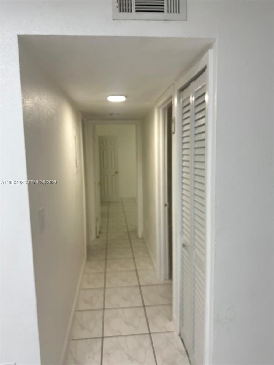 2565 West 56th Street, Unit 209 Hialeah, FL 33016 - Photo 5 of 10 a view of hallway with a large window and a shower