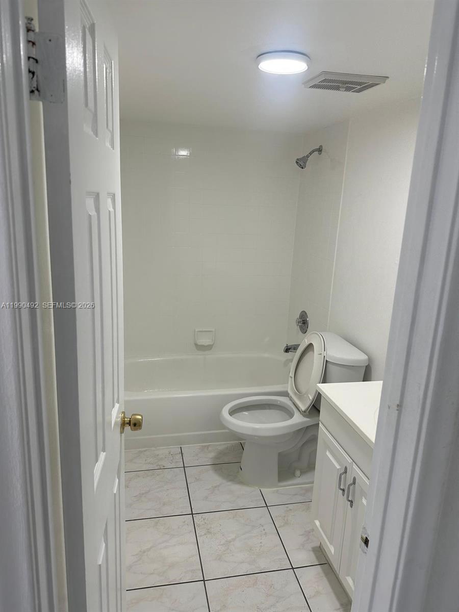 2565 West 56th Street, Unit 209 Hialeah, FL 33016 - Photo 6 of 10 a bathroom with a toilet a sink a mirror and bathtub