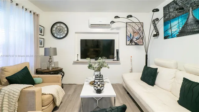 a living room with furniture a flat screen tv and a wall clock