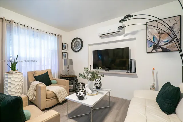 a living room with furniture a flat screen tv and a window