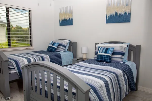 a bedroom with two beds and a painting on the wall