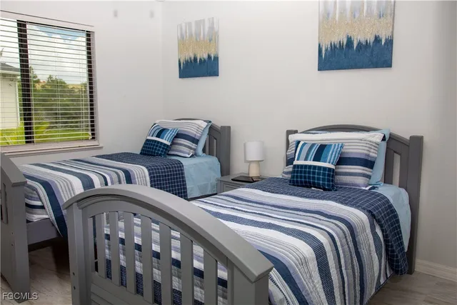 a bedroom with two beds and a painting on the wall