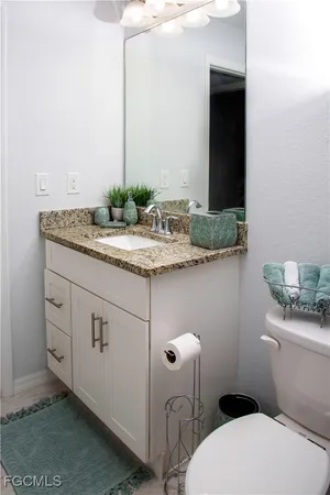 a bathroom with a granite countertop toilet sink and mirror