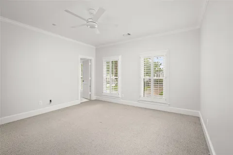 an empty room with a window and a ceiling fan