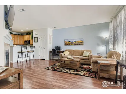 a living room with furniture a wooden floor and next to a window