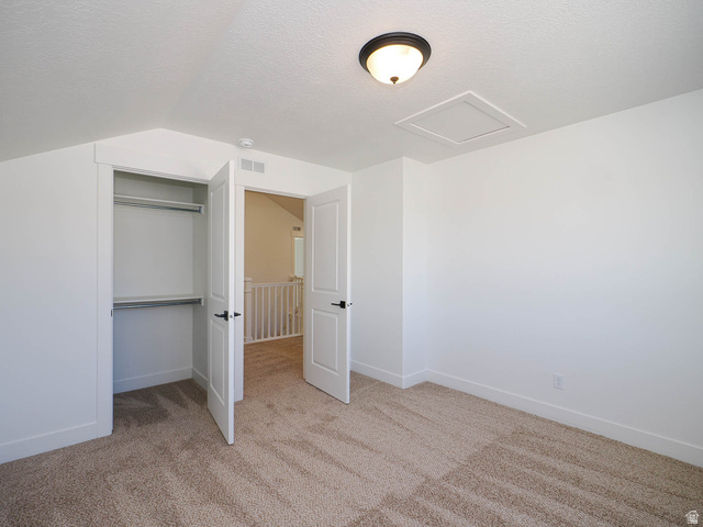 3938 North Wood Road Eagle Mountain, UT 84005 - Photo 40 of 55 Unfurnished bedroom featuring light colored carpet and a closet