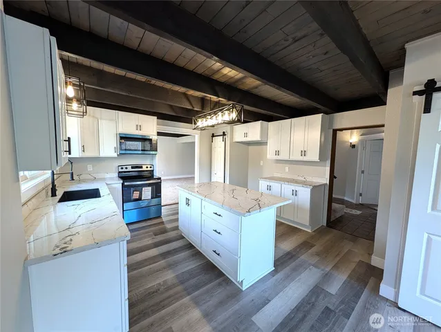 a kitchen with a sink window and stainless steel appliances
