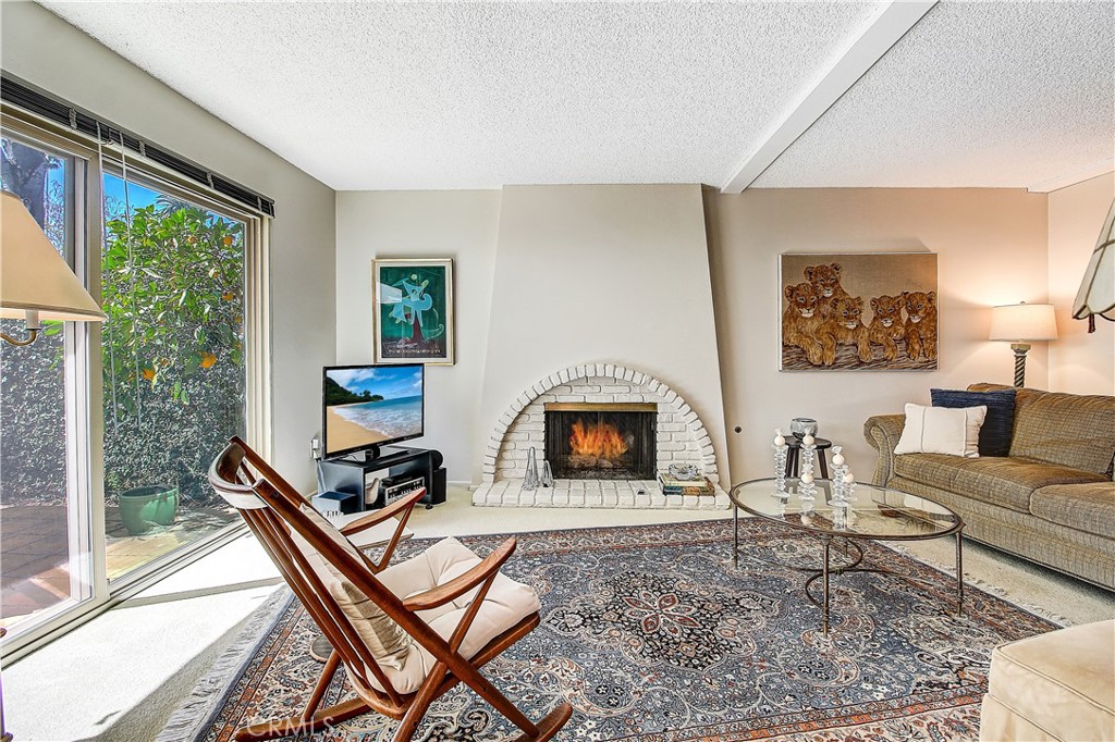 6618 Wintertree Drive Riverside, CA 92506 - Photo 9 of 37 a living room with furniture a fireplace and a floor to ceiling window
