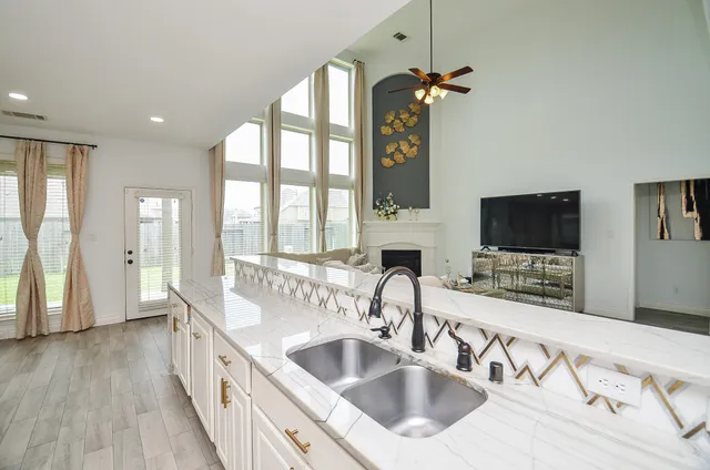 a view of a kitchen with kitchen island granite countertop a refrigerator and a sink