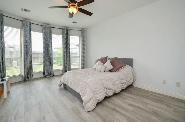 a spacious bedroom with a bed and large windows