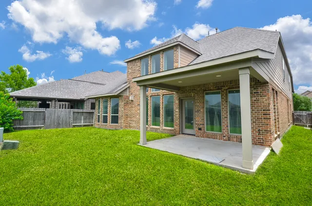 front view of a brick house with a yard