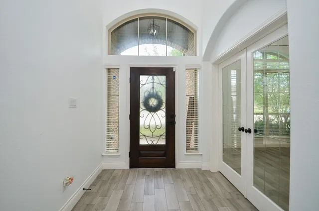 a view of a hallway with wooden floor and a window