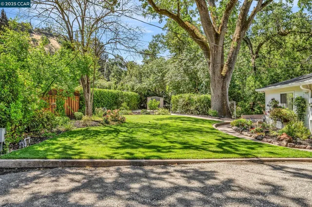 a view of a kitchen with kitchen island a sink wooden floor and a refrigerator