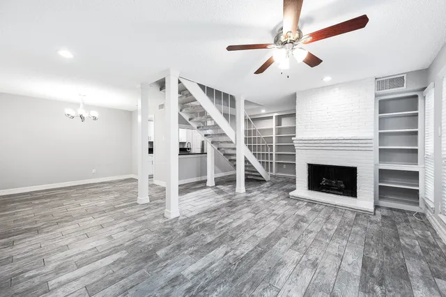 wooden floor fireplace and windows in the room