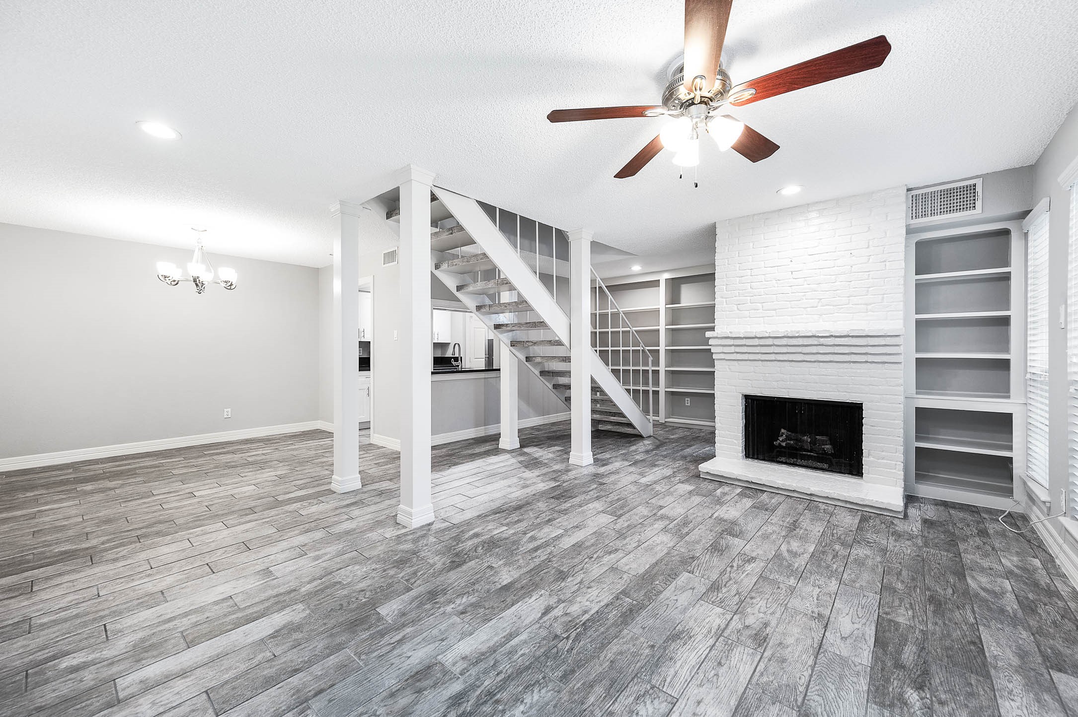 wooden floor fireplace and windows in the room