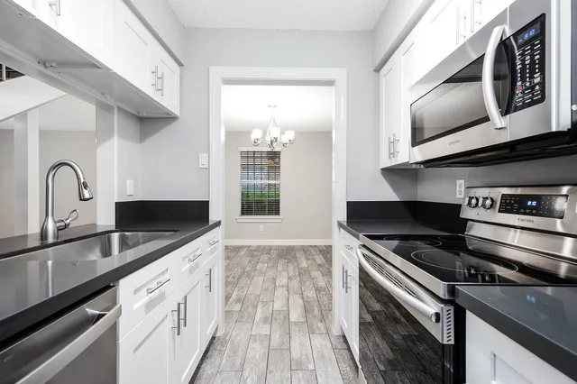 a kitchen with stainless steel appliances a sink stove and microwave