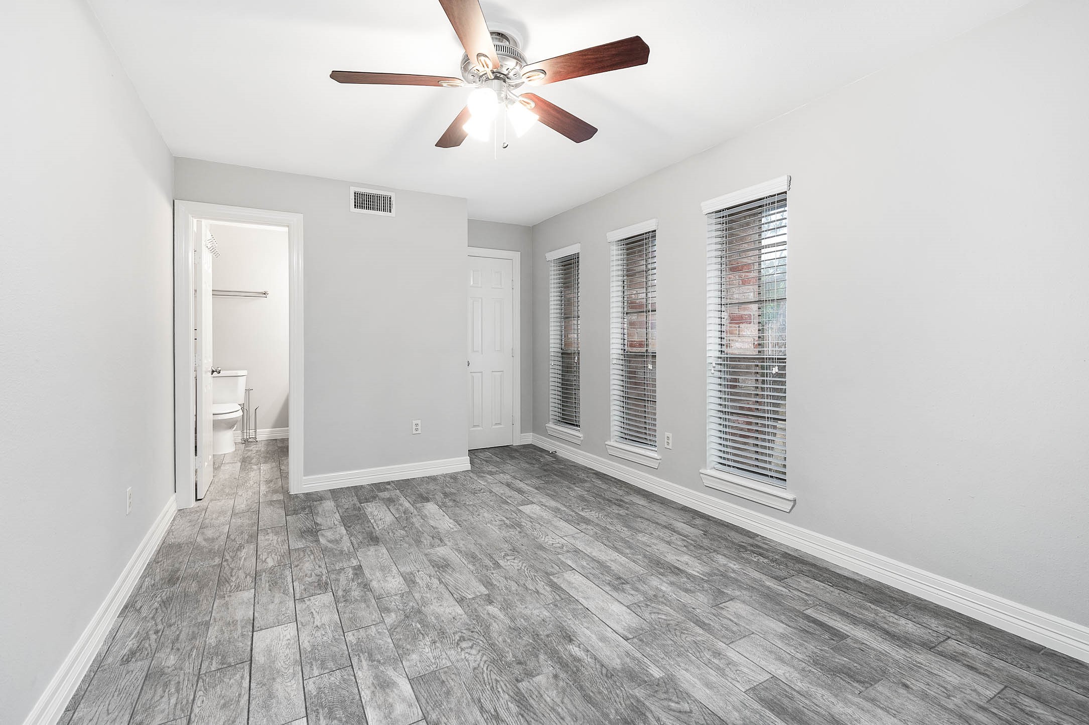 5528 Beverly Hill Street, Unit 1 Houston, TX 77056 - Photo 15 of 22 an empty room with wooden floor fan and windows