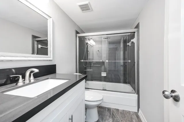 a bathroom with a sink a toilet and shower