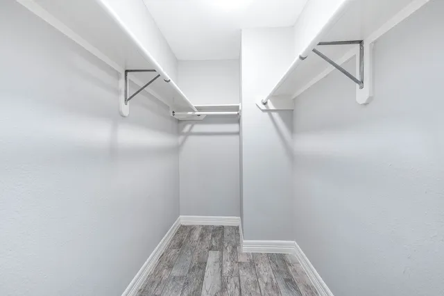 a view of walk in closet with empty racks