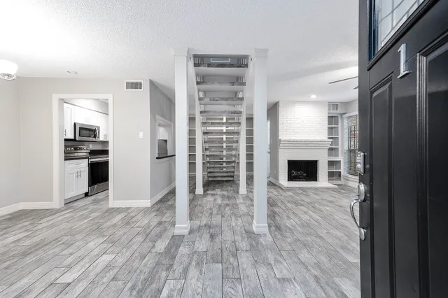 a view of open kitchen with wooden floor and a fireplace