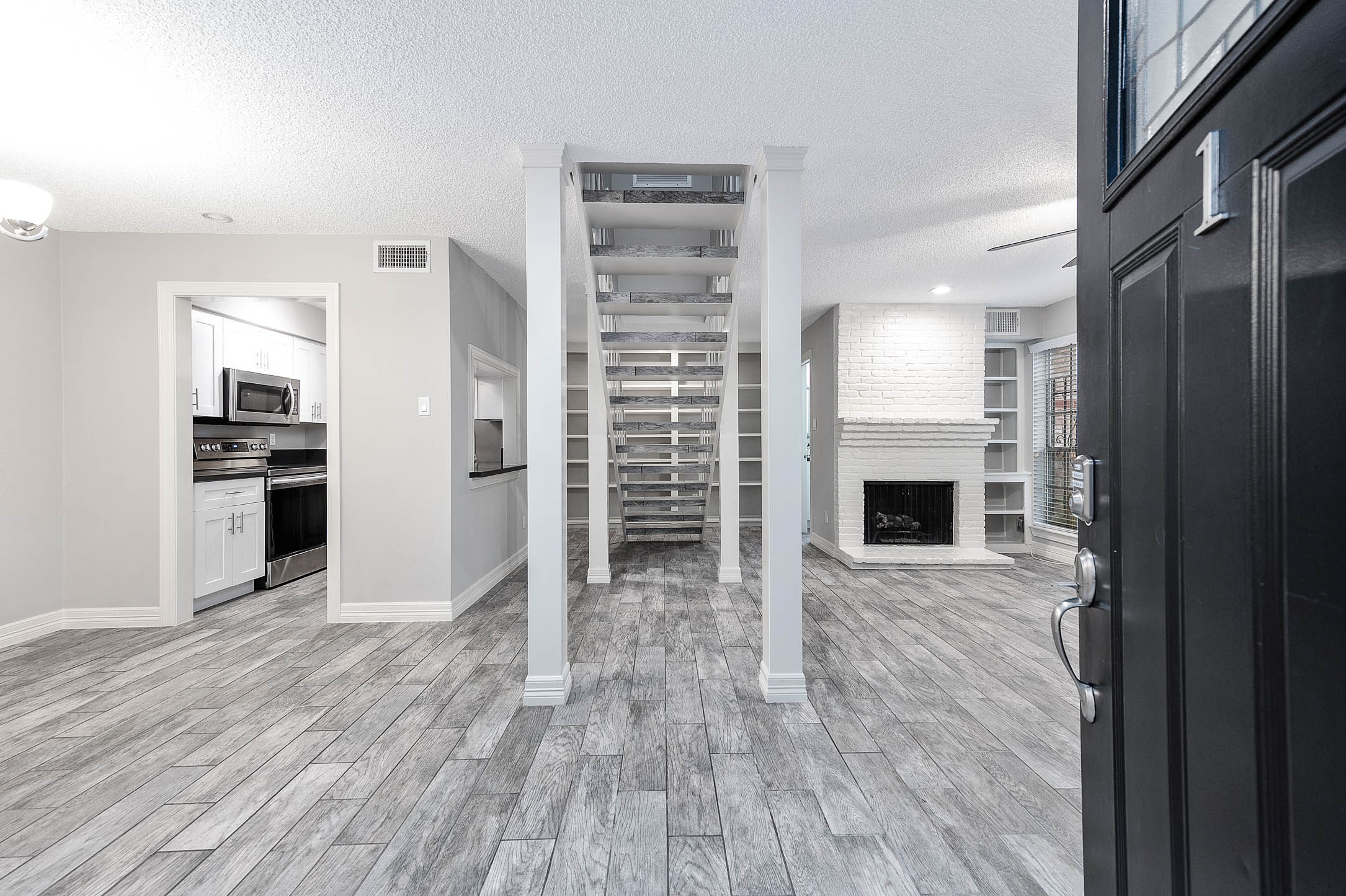 5528 Beverly Hill Street, Unit 1 Houston, TX 77056 - Photo 2 of 22 a view of open kitchen with wooden floor and a fireplace