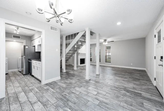 a view of a livingroom with wooden floor and a ceiling fan