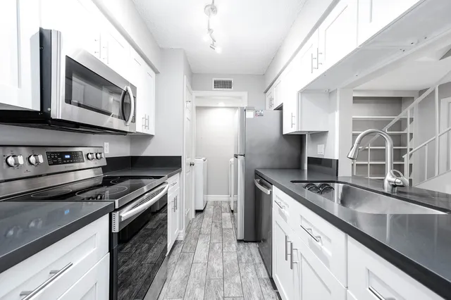 a kitchen with stainless steel appliances granite countertop a sink and a stove