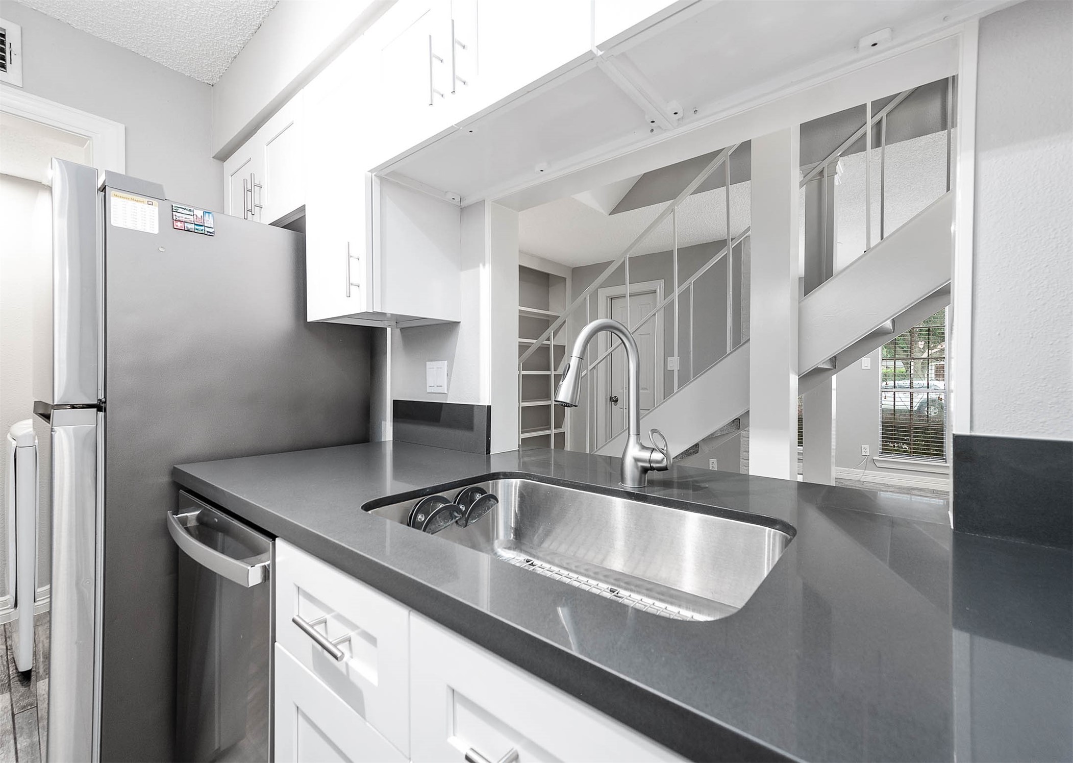 5528 Beverly Hill Street, Unit 1 Houston, TX 77056 - Photo 9 of 22 a kitchen with stainless steel appliances granite countertop a sink dishwasher and cabinets with wooden floor