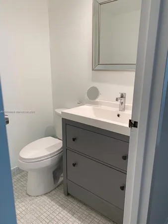 a bathroom with a toilet a sink and mirror
