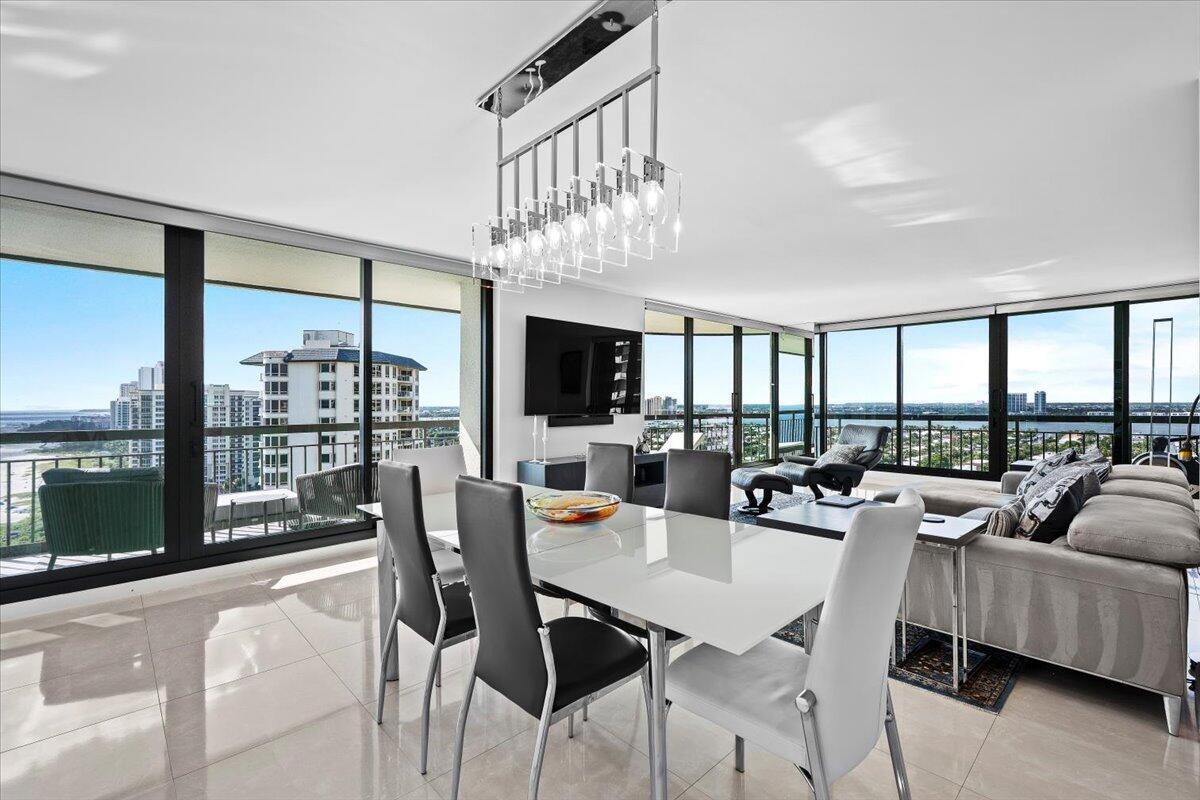 4000 North Ocean Drive, Unit 2004 Singer Island, FL 33404 - Photo 11 of 54 a dining room with furniture a chandelier and a floor to ceiling window