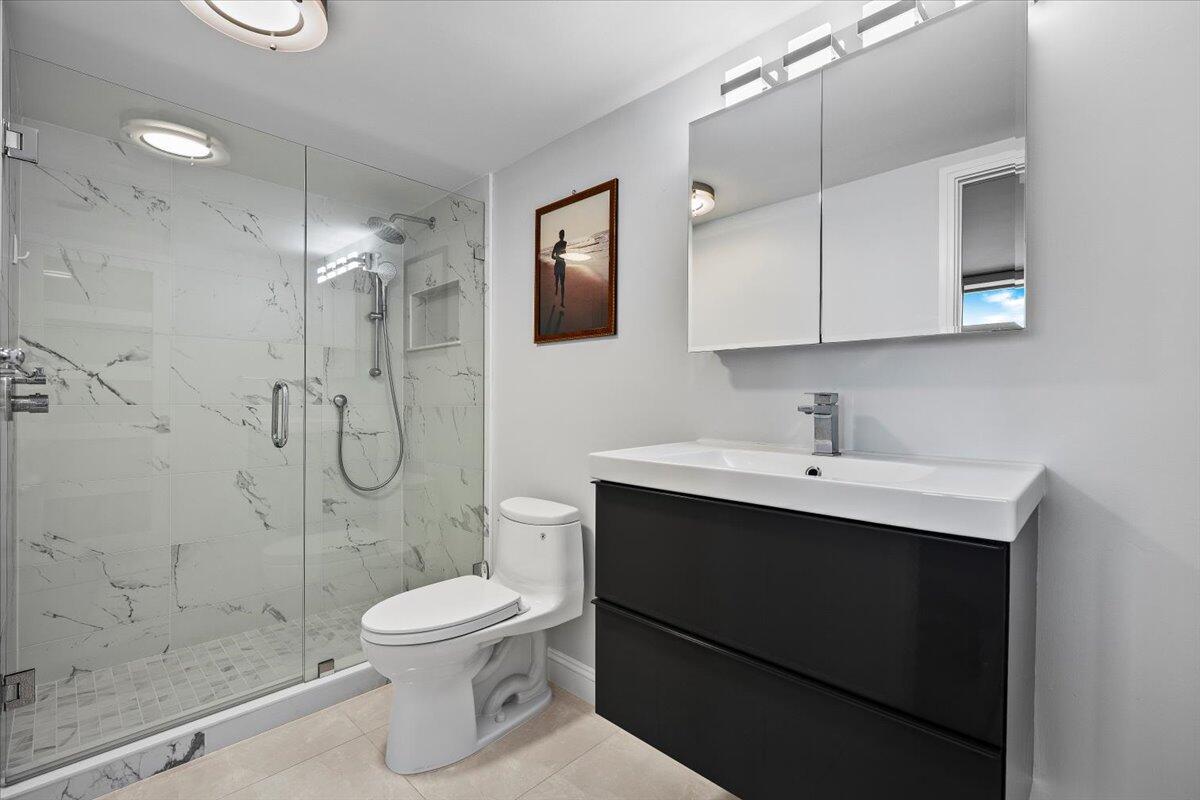 4000 North Ocean Drive, Unit 2004 Singer Island, FL 33404 - Photo 21 of 54 a bathroom with a shower sink mirror and toilet