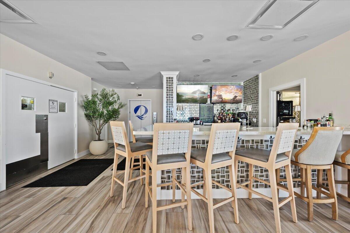 4000 North Ocean Drive, Unit 2004 Singer Island, FL 33404 - Photo 38 of 54 a dining room with furniture a rug potted plants and wooden floor