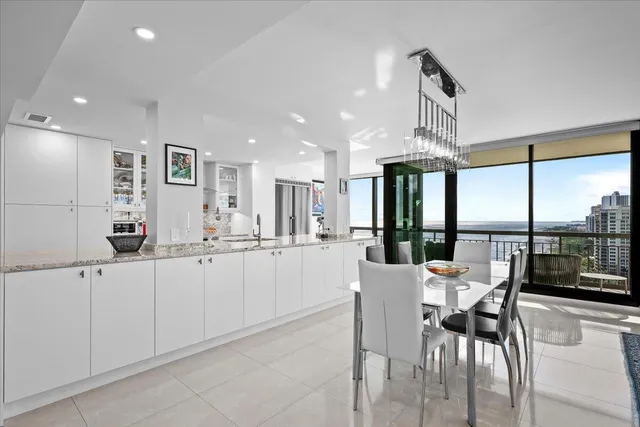 a kitchen with stainless steel appliances kitchen island granite countertop a table and chairs