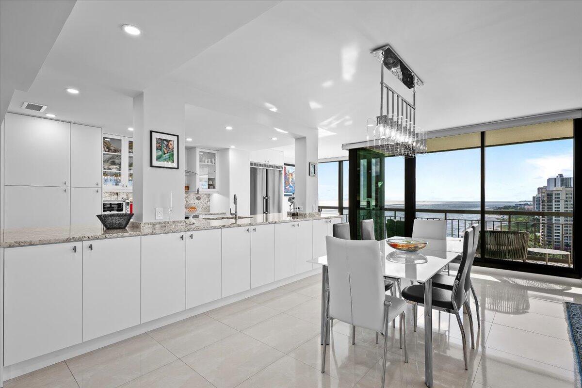 4000 North Ocean Drive, Unit 2004 Singer Island, FL 33404 - Photo 8 of 54 a kitchen with stainless steel appliances kitchen island granite countertop a table and chairs