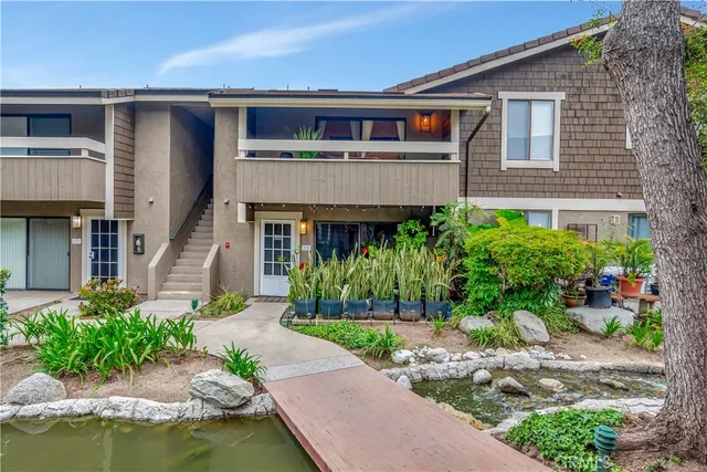 a front view of a house with a yard and potted plants