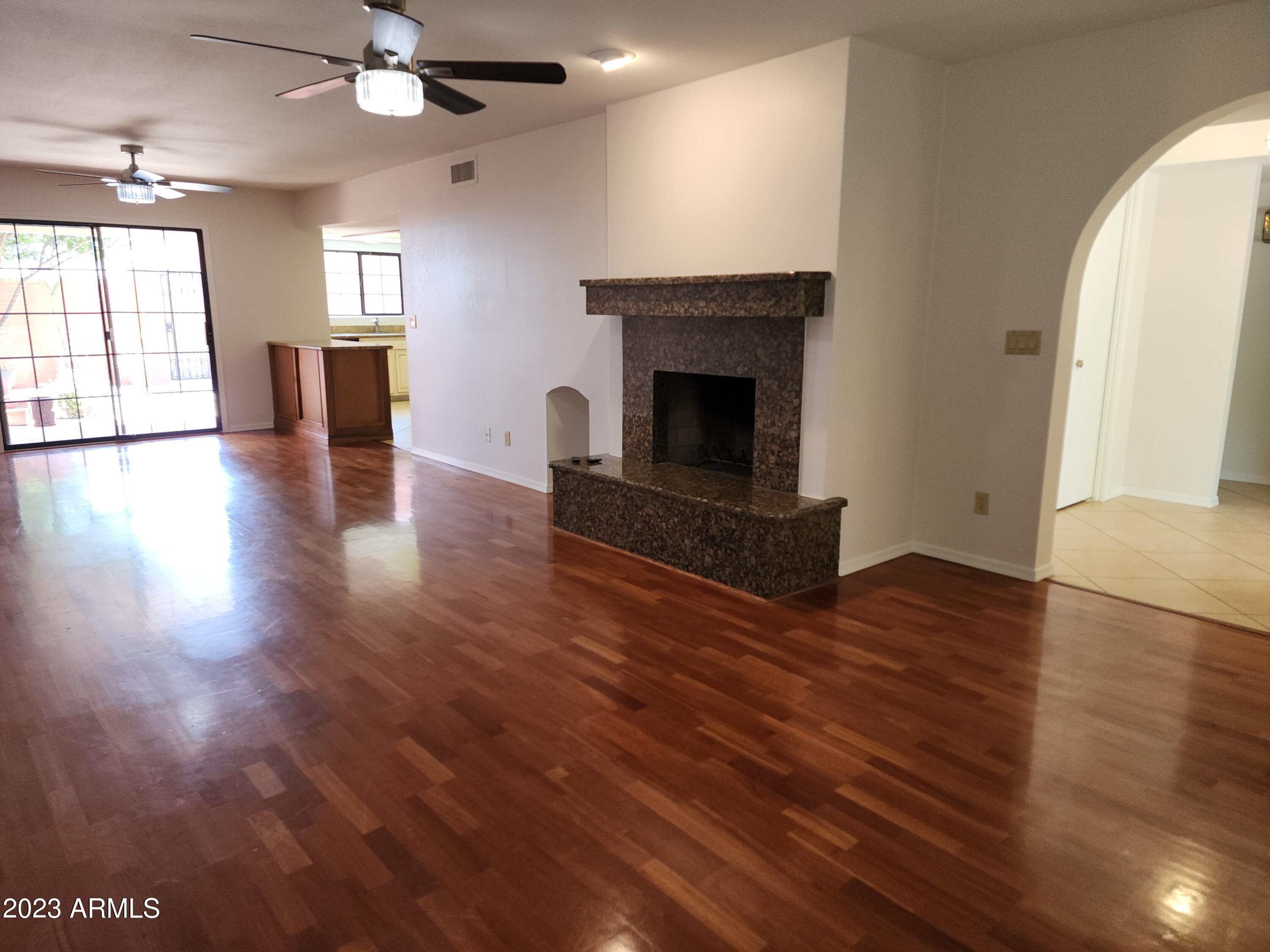 517 West Knox Road Chandler, AZ 85225 - Photo 10 of 14 an empty room with wooden floor a fireplace and windows