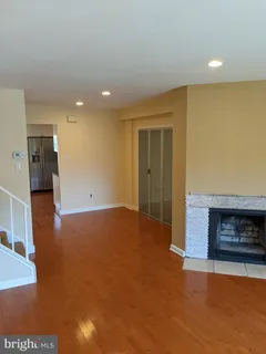 a view of empty room with wooden floor and fireplace