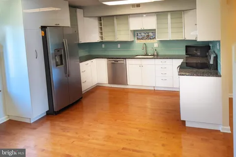 a kitchen with stainless steel appliances a refrigerator a sink a stove and cabinets